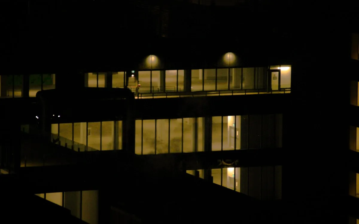 Building entrance lit by patrol vehicle headlights at night